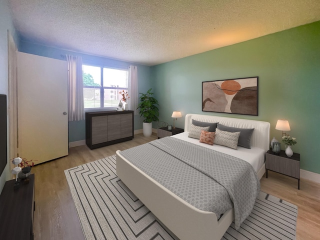 bedroom featuring light wood-type flooring and a textured ceiling