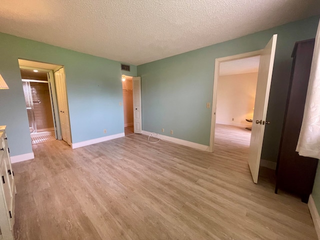 unfurnished bedroom featuring light wood-type flooring and a textured ceiling