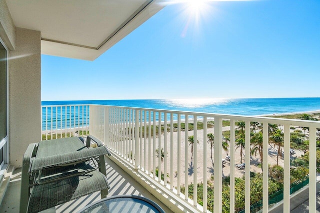 balcony with a water view and a view of the beach