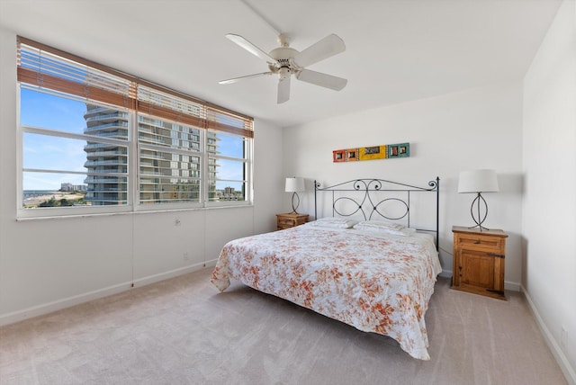 bedroom with light colored carpet, multiple windows, and ceiling fan