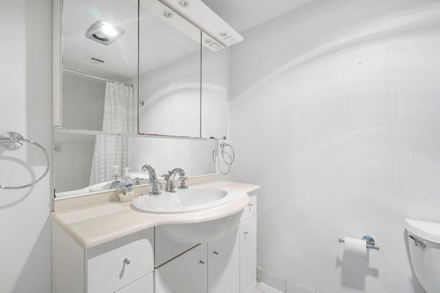 bathroom with a shower with curtain, vanity, and toilet