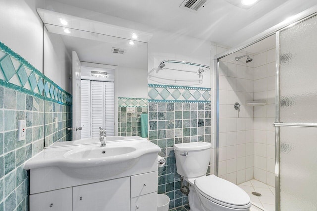 bathroom featuring vanity, toilet, and tile walls