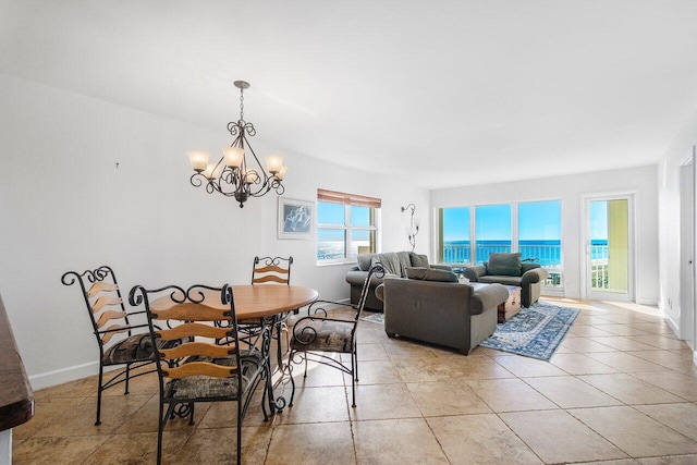 tiled dining space with a water view and a chandelier