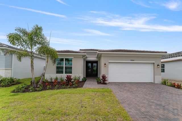 view of front of property with a garage and a front lawn