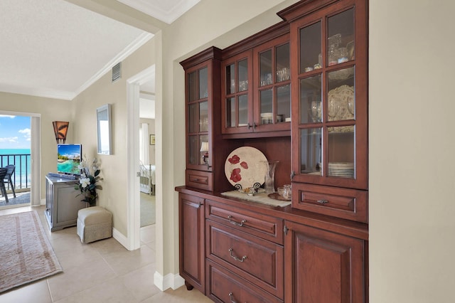 corridor featuring crown molding and light tile patterned floors