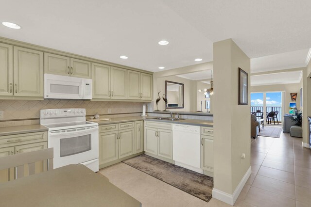 kitchen featuring white appliances, light tile patterned floors, an inviting chandelier, backsplash, and sink