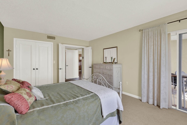 carpeted bedroom featuring a closet and a textured ceiling