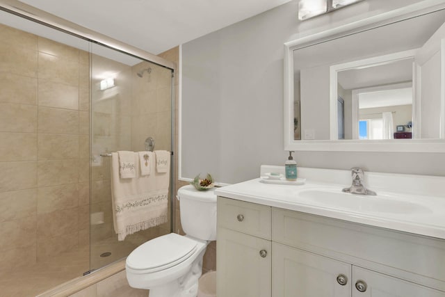 bathroom with a shower with shower door, vanity, and toilet