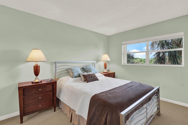 bedroom featuring a textured ceiling and light colored carpet