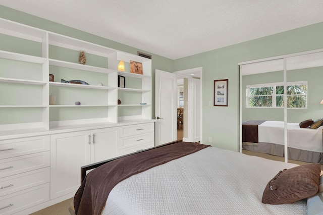 bedroom with light carpet and a textured ceiling