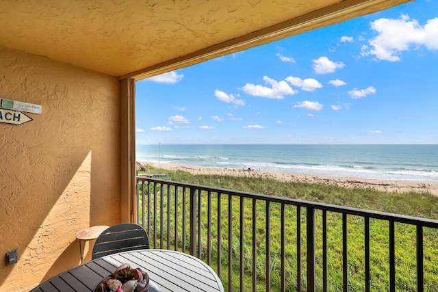 balcony with a beach view and a water view