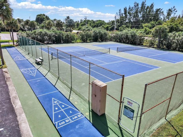 view of home's community featuring tennis court