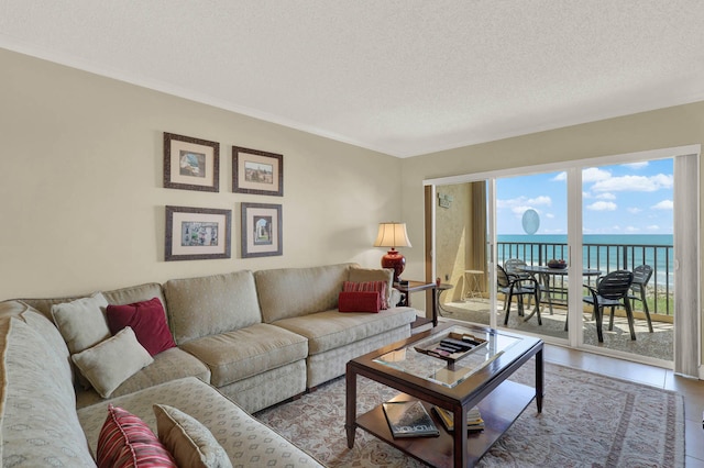 tiled living room with a water view and a textured ceiling