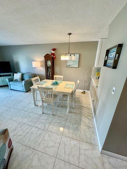 dining space with light tile patterned floors and a textured ceiling