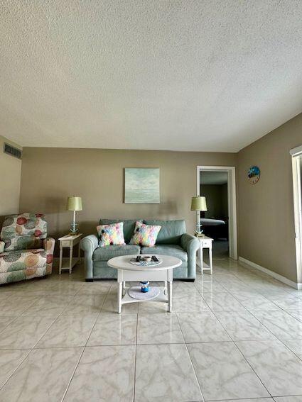 tiled living room with a textured ceiling