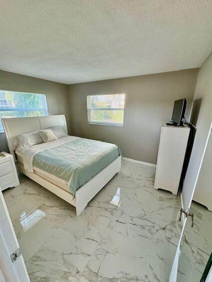 bedroom featuring a textured ceiling and light tile patterned floors