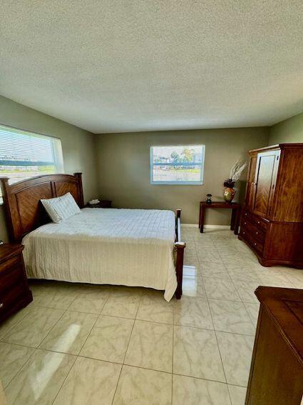 bedroom featuring light tile patterned floors and a textured ceiling