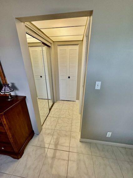 hall with light tile patterned floors