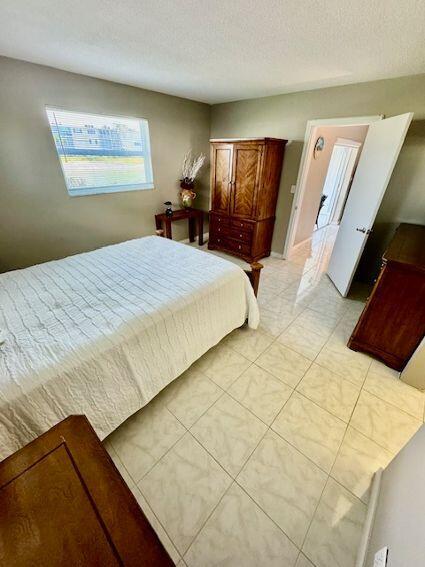 bedroom with a textured ceiling and light tile patterned floors