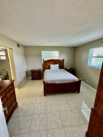 bedroom featuring a textured ceiling and light tile patterned floors