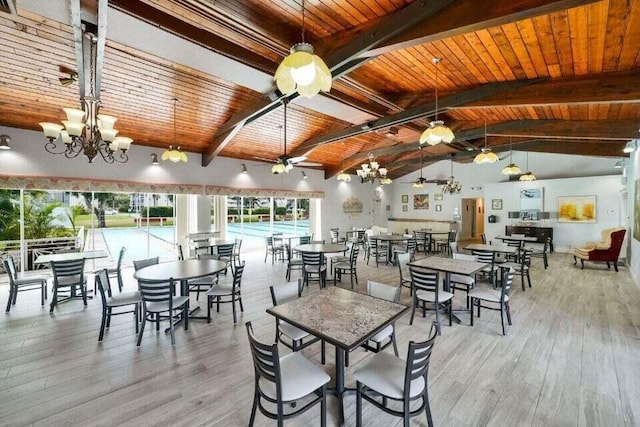 dining room featuring light wood-type flooring, ceiling fan with notable chandelier, and wood ceiling