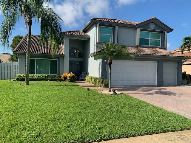 mediterranean / spanish house with a front lawn and a garage