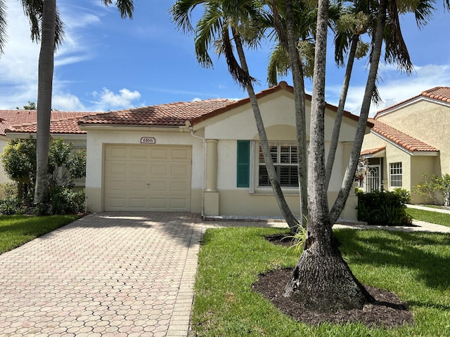 mediterranean / spanish-style house with a garage and a front yard