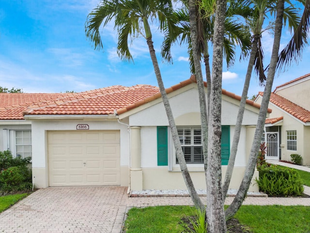 6166 Lake Hibiscus Dr, Delray Beach, FL 33484 - view of front of house with a garage, decorative driveway, stucco siding, and a tile roof