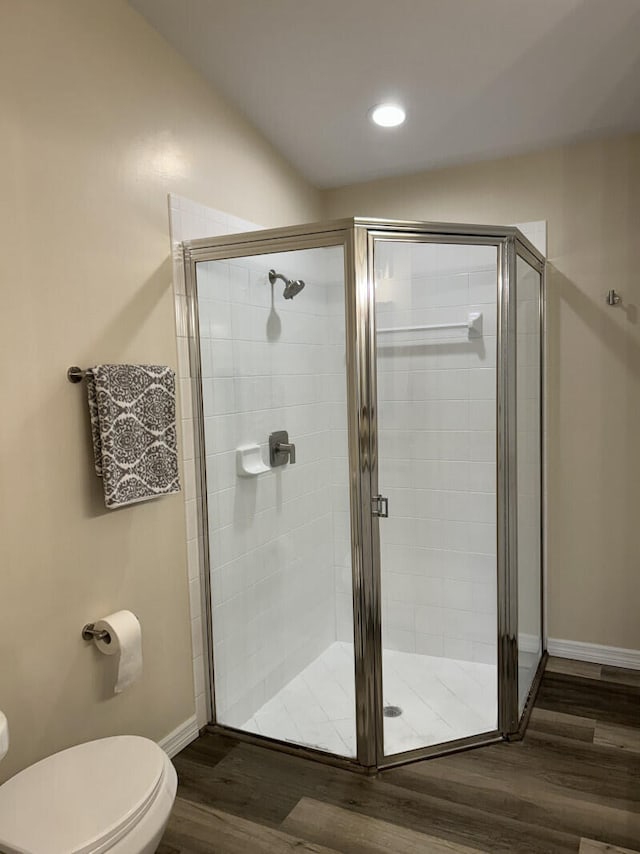 bathroom featuring walk in shower, wood-type flooring, and toilet