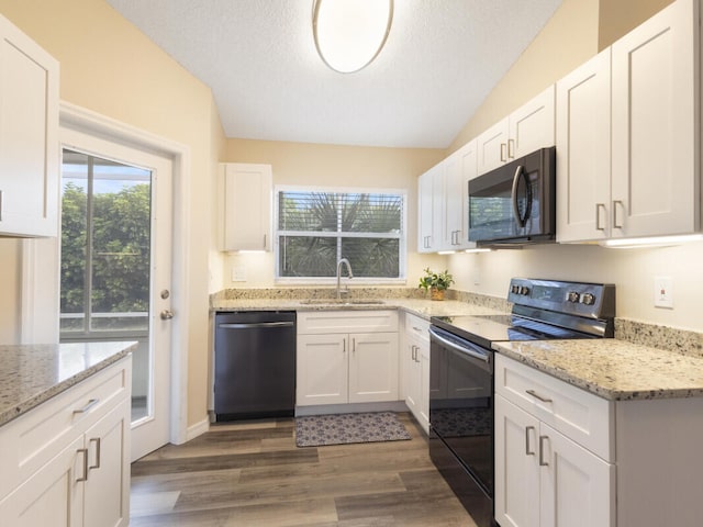 6166 Lake Hibiscus Dr, Delray Beach, FL 33484 - kitchen with black appliances, a sink, wood finished floors, white cabinets, and light stone countertops