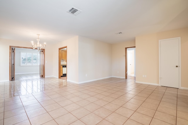 tiled spare room with a chandelier