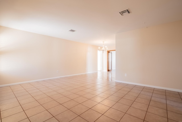 tiled empty room with a notable chandelier