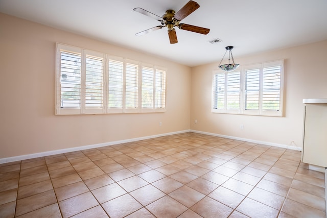 empty room with ceiling fan and light tile patterned floors