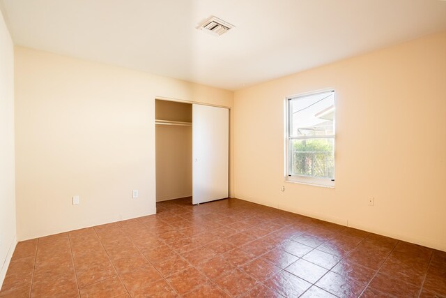 unfurnished bedroom with tile patterned flooring and a closet