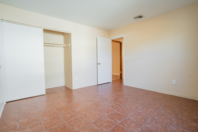 unfurnished bedroom with tile patterned floors and a closet