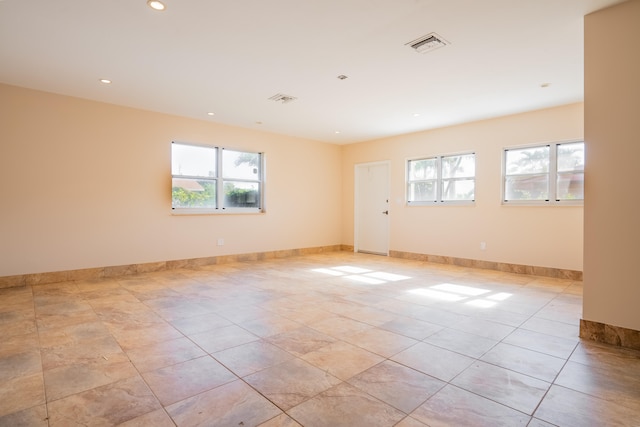 spare room featuring plenty of natural light and light tile patterned flooring