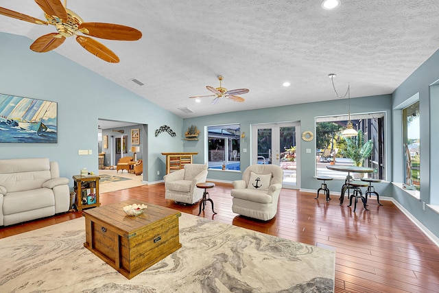 living room featuring french doors, wood-type flooring, vaulted ceiling, a textured ceiling, and ceiling fan