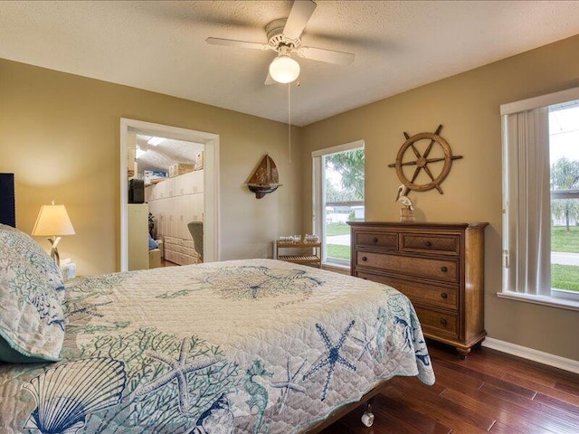 bedroom with multiple windows, dark wood-type flooring, a textured ceiling, and ceiling fan