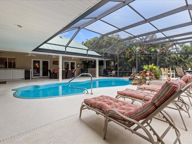 view of pool with an outdoor living space, a patio, a lanai, and ceiling fan