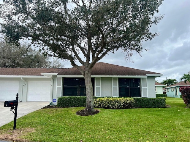 single story home with concrete driveway, a front lawn, an attached garage, and stucco siding