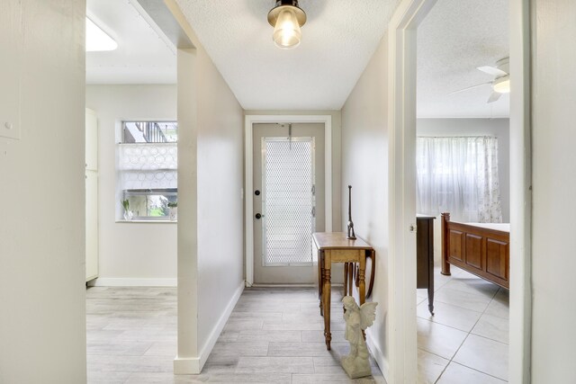 tiled foyer featuring ceiling fan and a textured ceiling