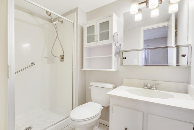 bathroom with tile patterned floors, vanity, toilet, and a shower with shower door