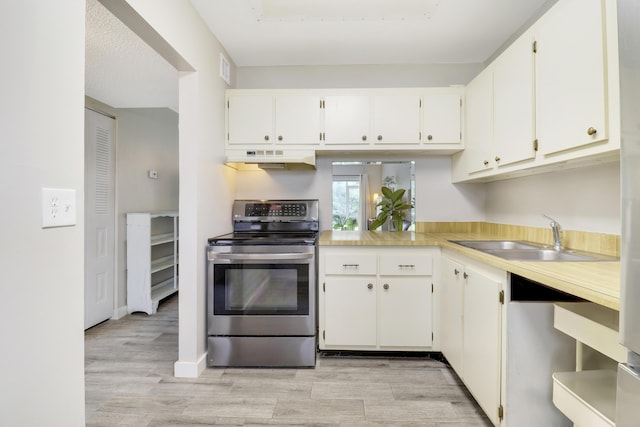 kitchen featuring white cabinetry, appliances with stainless steel finishes, sink, and light hardwood / wood-style flooring