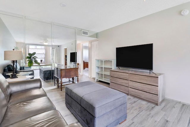 living room featuring light wood-type flooring and ceiling fan