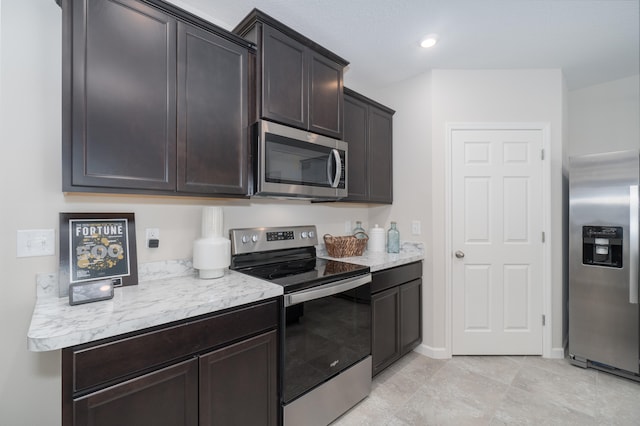 kitchen with light tile patterned flooring, stainless steel appliances, and dark brown cabinetry