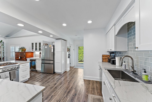 kitchen with white cabinetry, sink, stainless steel appliances, and light stone countertops