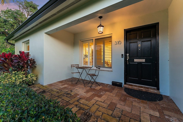 exterior entry at dusk featuring a porch