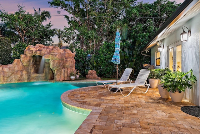 pool at dusk with a patio