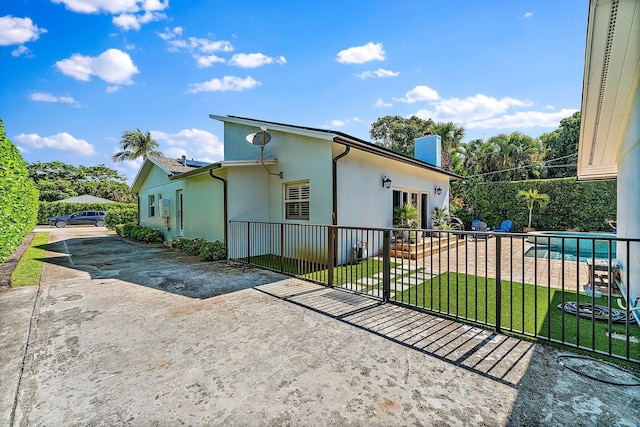 view of side of property with a fenced in pool and a lawn