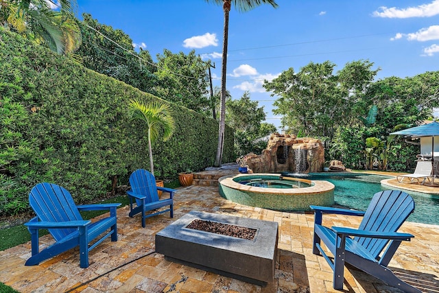 view of patio with a swimming pool with hot tub and a fire pit